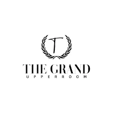 Elegant logo of The Grand Upper Room featuring a stylized 'T' surrounded by laurel leaves, representing a sophisticated venue for events and gatherings.