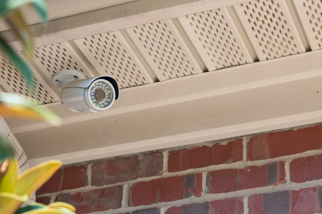 Outdoor security camera mounted under a porch soffit